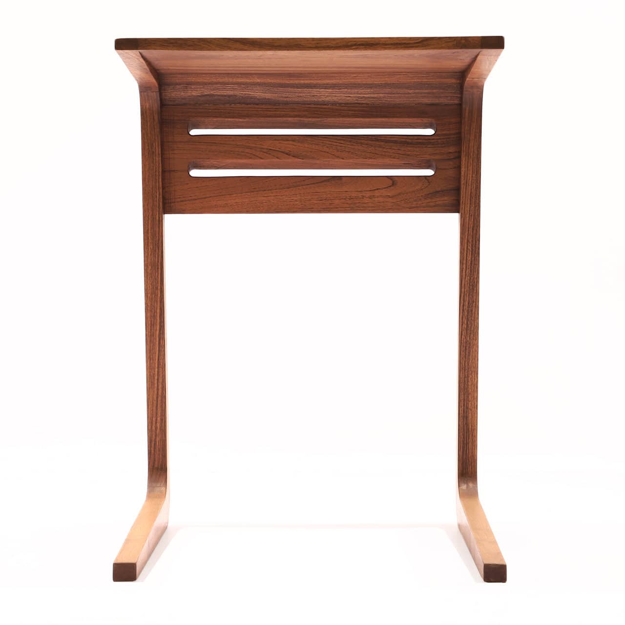 Introducing the Sleek Work Desk by Tooba Furniture Factory: a contemporary wooden side table with an elegant, curved design made from premium teak wood grains. This desk boasts a C-shaped frame and a smooth, polished finish. Its flat top surface and two horizontal side slits provide subtle design flair, making it the perfect lightweight mobile desk for remote workers.