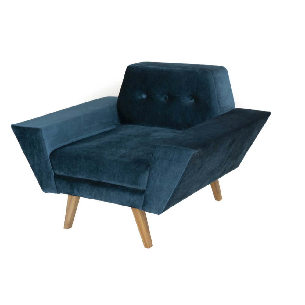 The Wide Armset Sofa from Tooba Furniture Factory is a modern, dark blue velvet armchair with wooden legs. It features a unique design with one extended armrest, a button-tufted backrest, and angled lines that give it a contemporary and stylish appearance. The chair is displayed against a plain white background.