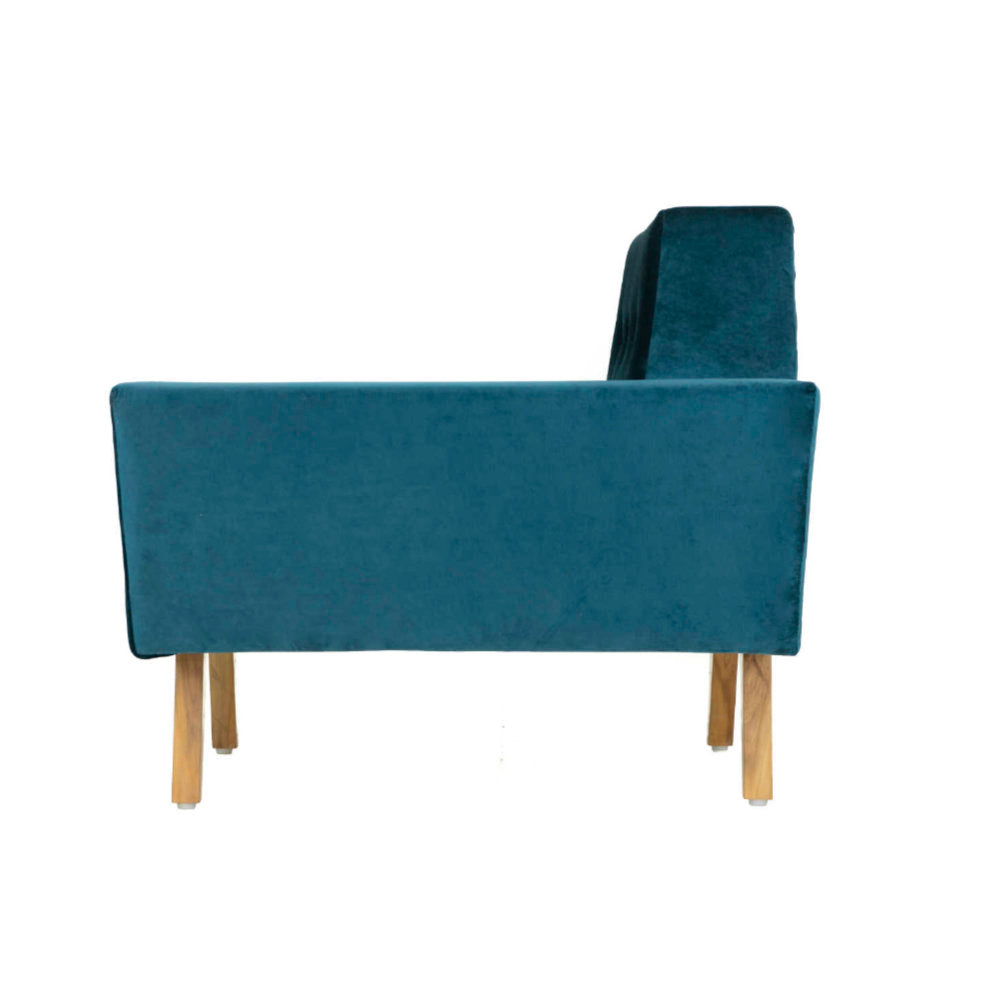 The Wide Armset Sofa from Tooba Furniture Factory is a modern, dark blue velvet armchair with wooden legs. It features a unique design with one extended armrest, a button-tufted backrest, and angled lines that give it a contemporary and stylish appearance. The chair is displayed against a plain white background.