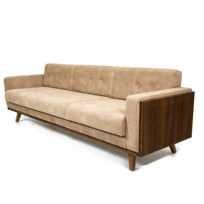 The Veneer Edge Sofa by Tooba Furniture Factory is a modern beige sofa that boasts a minimalist design with wooden side panels and legs. The tufted backrest, adorned with buttons, provides a subtle decorative touch. Positioned at an angle to showcase its full form, the sofa highlights its clean lines and contemporary look.