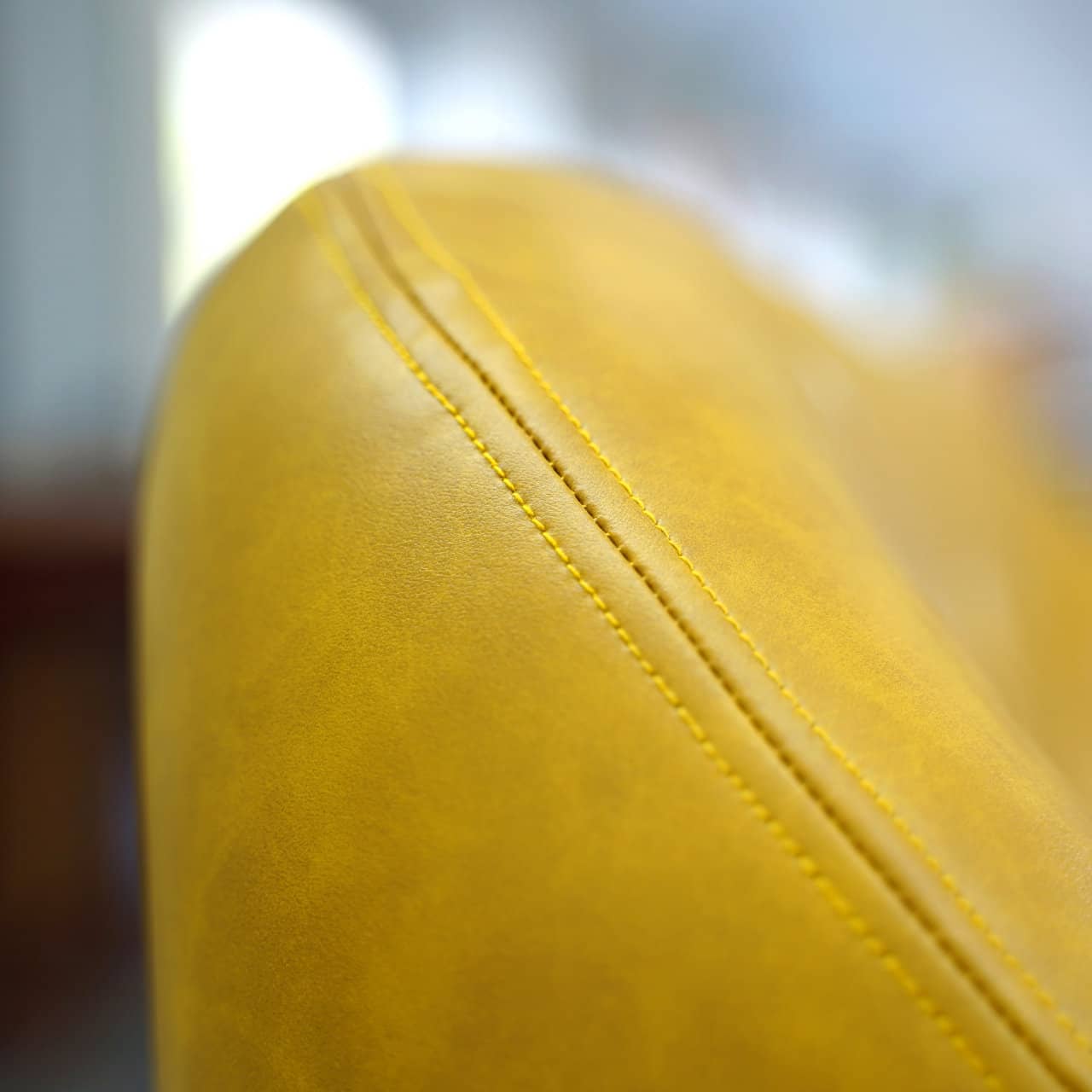 Introducing the Neo-Classical Sofa by Tooba Furniture Factory, a stylish yellow sofa featuring a tufted backrest, curved armrests, and sleek black legs. This modern piece boasts smooth upholstery and is designed to comfortably seat two people, making it ideal for contemporary interiors.