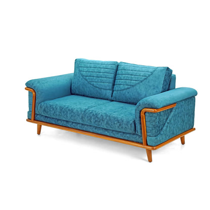 The Quantum Sofa by Tooba Furniture Factory is a modern teal upholstered piece that boasts a wooden frame and legs. It features simple, clean lines, cushioned armrests, and an angled backrest with a quilted design. Wooden accents enhance its stylish and contemporary appeal.